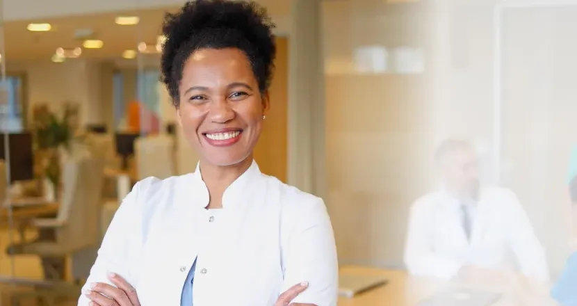 DNP nurse executive smiling in conference room during team meeting